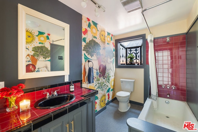 full bathroom featuring rail lighting, shower / bath combo, vanity, tile patterned floors, and toilet