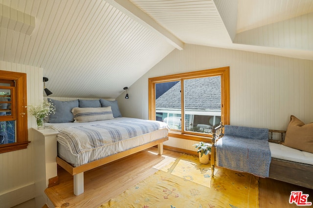 bedroom with vaulted ceiling with beams and hardwood / wood-style floors