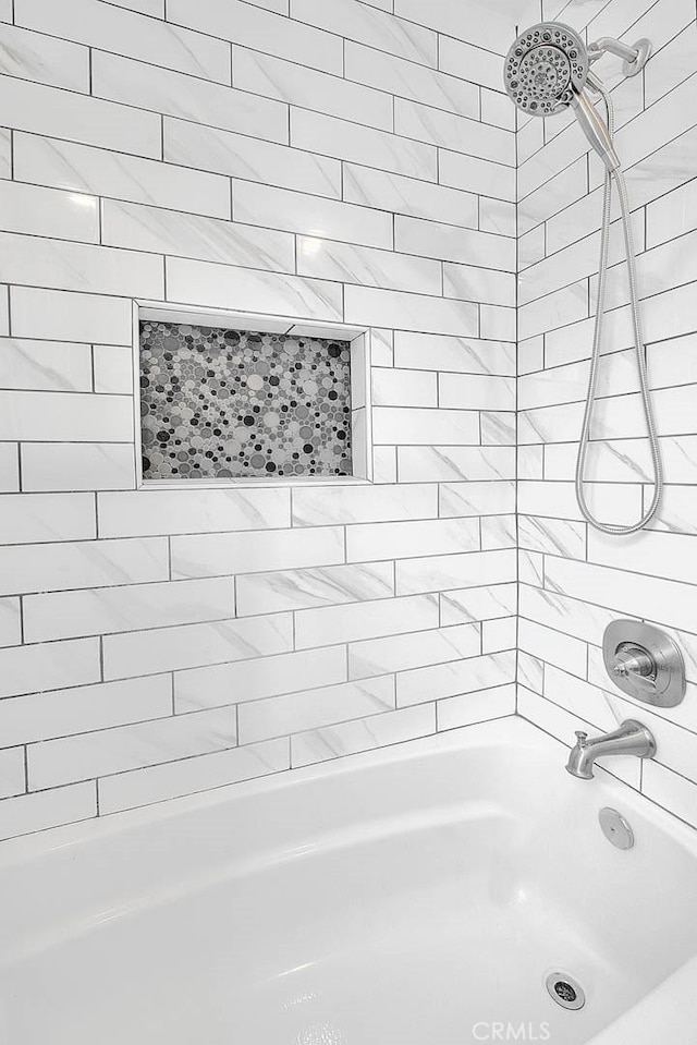 bathroom featuring tiled shower / bath