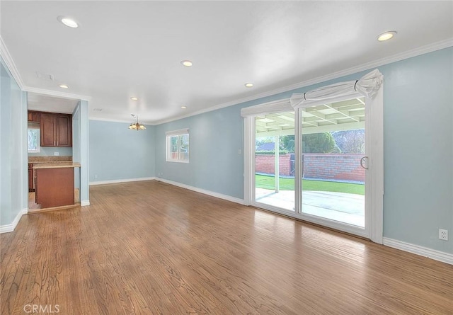 unfurnished living room featuring crown molding and light wood-type flooring