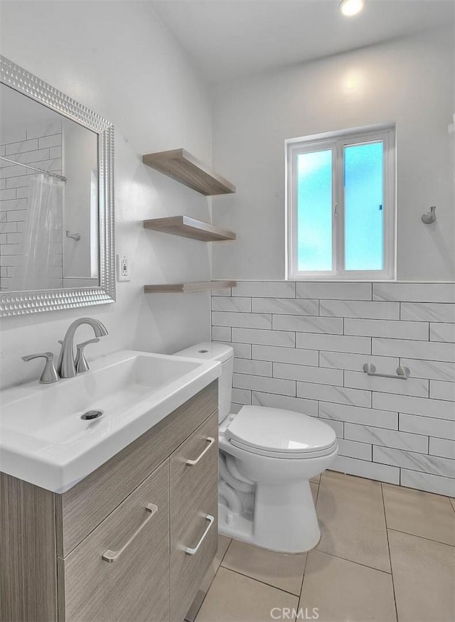 bathroom featuring tile walls, tile patterned flooring, vanity, curtained shower, and toilet