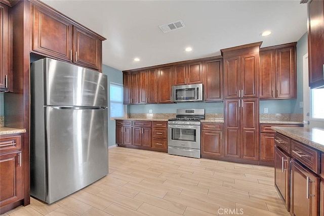 kitchen featuring stainless steel appliances and light stone counters