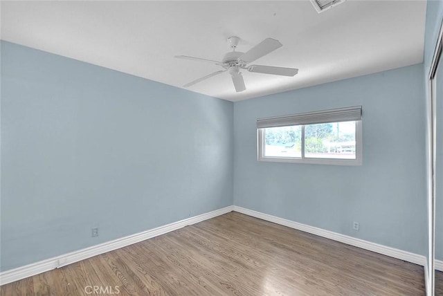 empty room with hardwood / wood-style flooring and ceiling fan