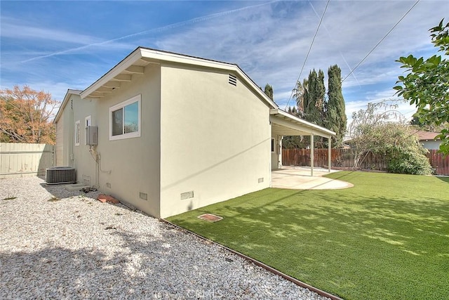 view of side of property featuring central AC, a patio area, and a lawn