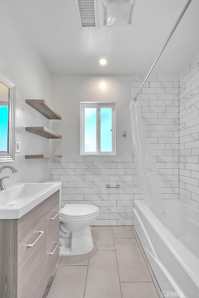 full bathroom featuring tile walls, shower / tub combo, tile patterned flooring, vanity, and toilet