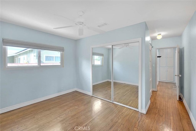 unfurnished bedroom with ceiling fan, light hardwood / wood-style floors, and a closet