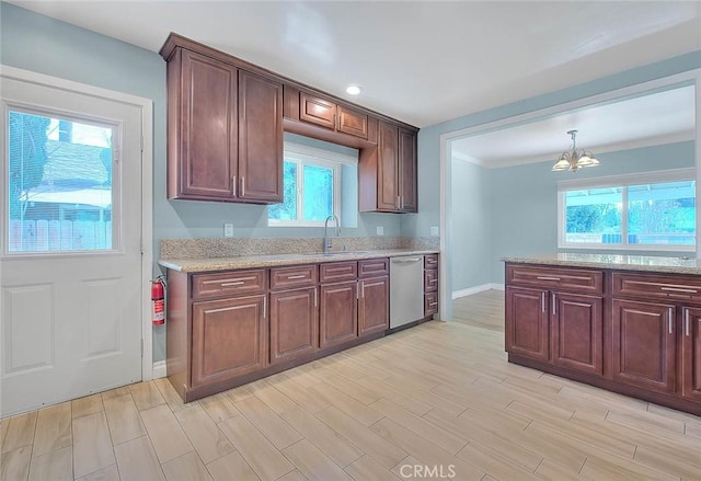 kitchen featuring sink, hanging light fixtures, stainless steel dishwasher, light stone countertops, and light hardwood / wood-style flooring