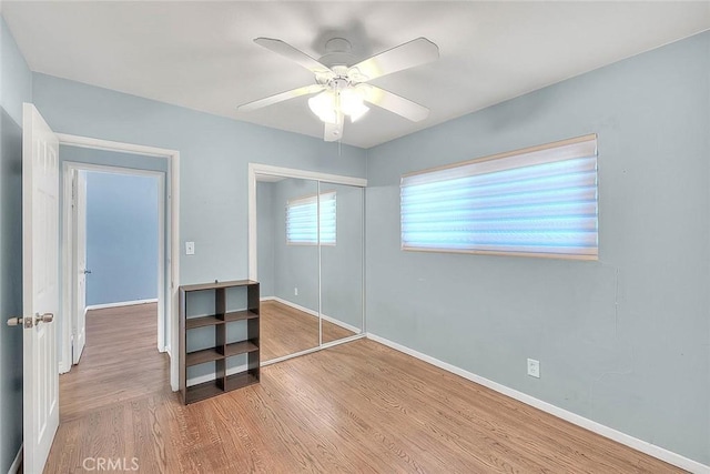 unfurnished bedroom featuring a closet, ceiling fan, and light wood-type flooring