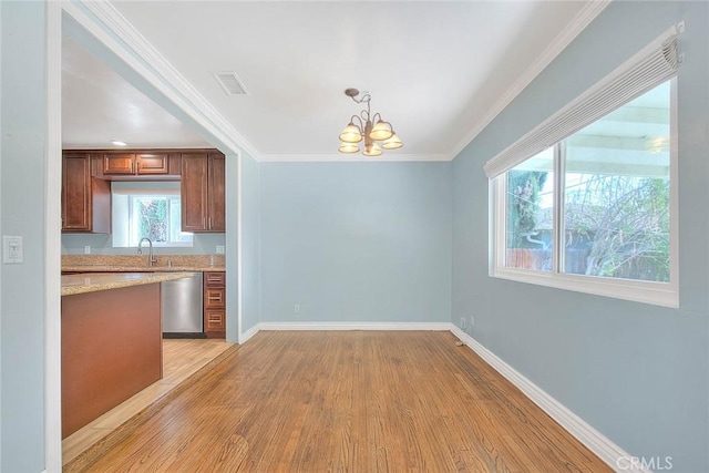 kitchen featuring hanging light fixtures, stainless steel dishwasher, a notable chandelier, light stone counters, and light hardwood / wood-style floors