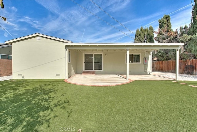 back of house featuring a patio and a lawn