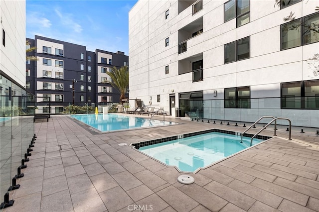 view of pool featuring a community hot tub and a patio