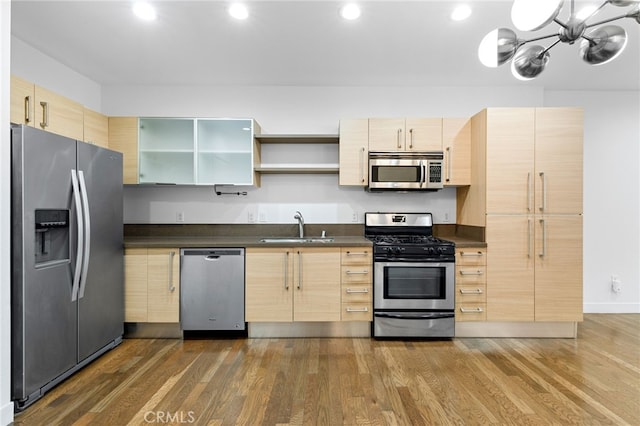 kitchen featuring dark wood-type flooring, stainless steel appliances, light brown cabinetry, and sink