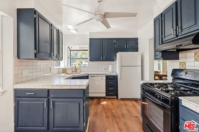 kitchen featuring sink, white appliances, ceiling fan, light hardwood / wood-style floors, and decorative backsplash