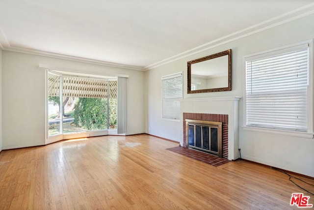 unfurnished living room with hardwood / wood-style flooring, a fireplace, and ornamental molding