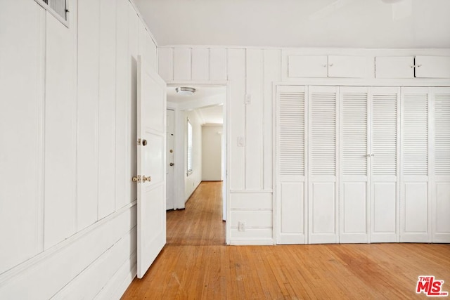 unfurnished bedroom featuring light hardwood / wood-style flooring and a closet