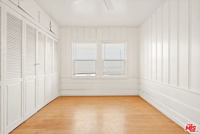 unfurnished bedroom with ceiling fan, a closet, and light hardwood / wood-style flooring