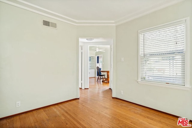 unfurnished room featuring crown molding and light wood-type flooring