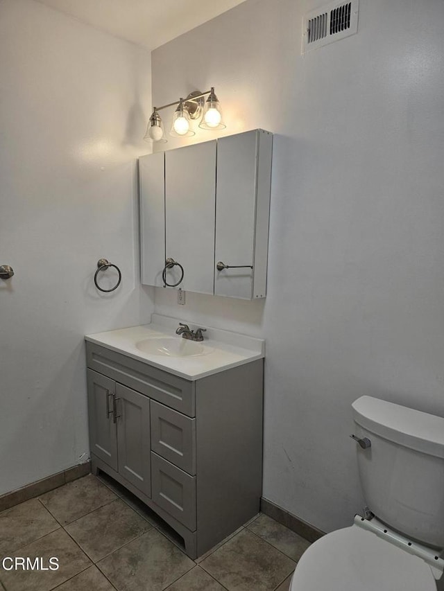 bathroom with vanity, toilet, and tile patterned flooring