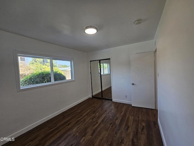 unfurnished bedroom featuring dark hardwood / wood-style flooring and a closet