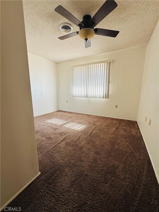 carpeted spare room with ceiling fan and a textured ceiling