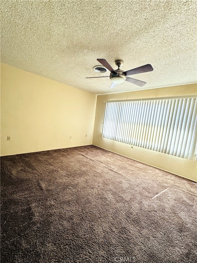 carpeted spare room featuring a textured ceiling and ceiling fan