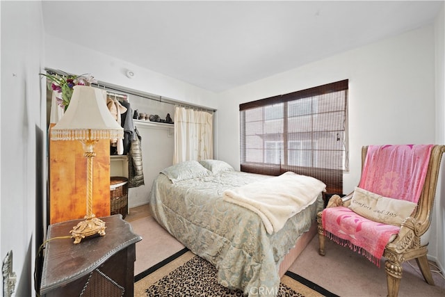 bedroom with light colored carpet and a closet