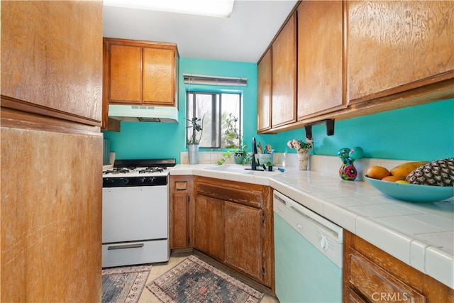 kitchen with sink, tile countertops, and white appliances