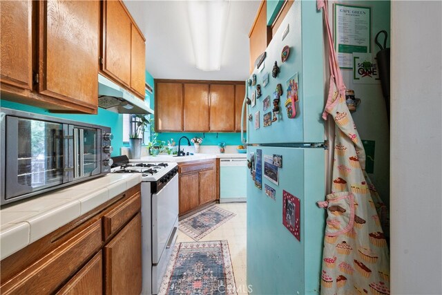 kitchen featuring tile counters and white appliances