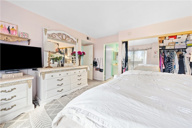 bedroom with ensuite bathroom and a closet