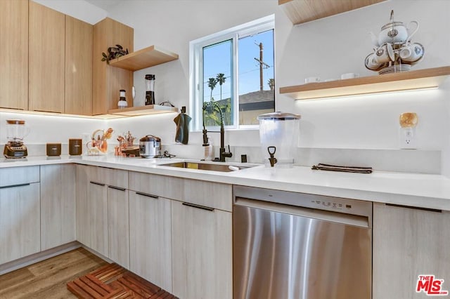 kitchen with light hardwood / wood-style floors, stainless steel dishwasher, light brown cabinetry, and sink