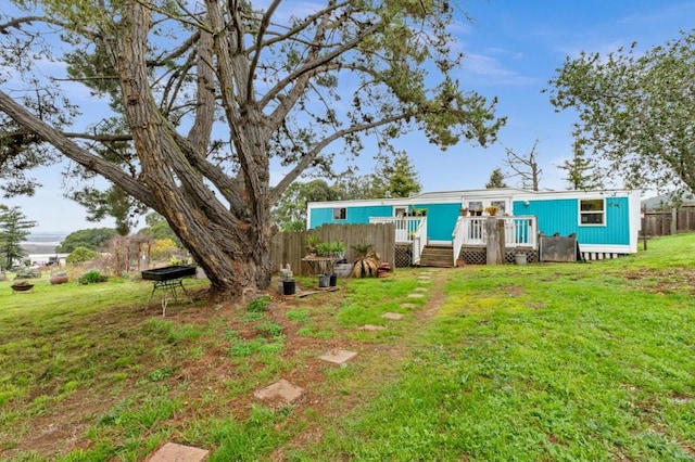 rear view of house featuring a yard and a deck