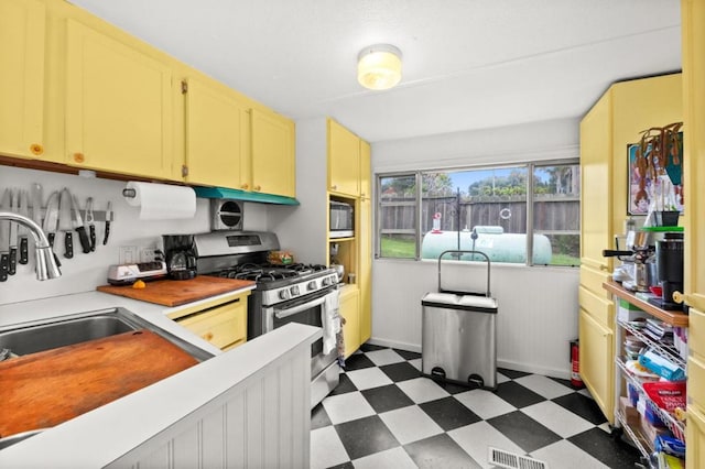 kitchen featuring black microwave, sink, and gas stove