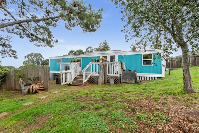 back of property featuring a lawn and a deck