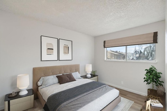 bedroom featuring hardwood / wood-style floors and a textured ceiling