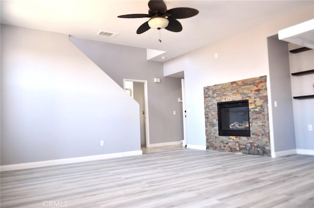 unfurnished living room featuring ceiling fan, a fireplace, and light hardwood / wood-style floors