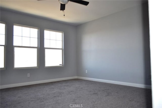 carpeted spare room featuring ceiling fan