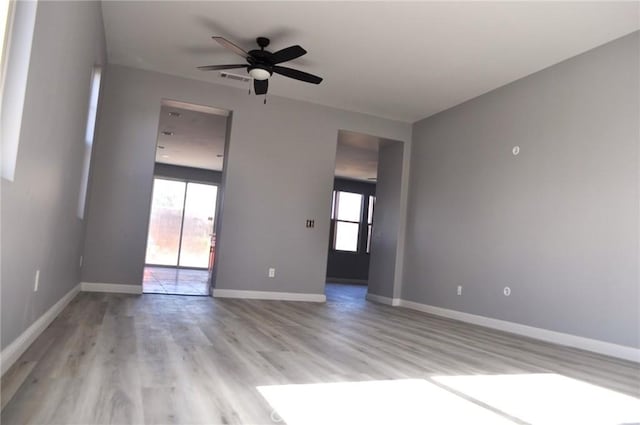 unfurnished room featuring a wealth of natural light, light hardwood / wood-style flooring, and ceiling fan