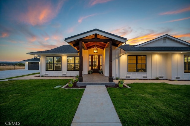 view of front of home with a garage and a yard