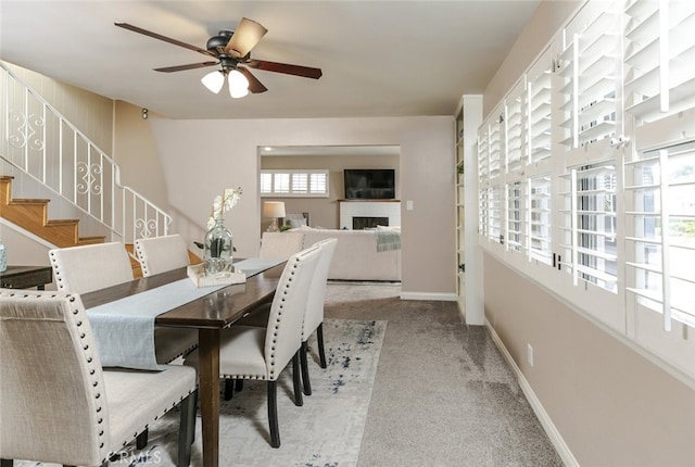 dining area featuring ceiling fan and light carpet