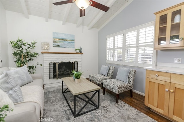 living room featuring ceiling fan, vaulted ceiling with beams, dark hardwood / wood-style flooring, a brick fireplace, and wooden ceiling