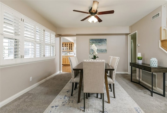 dining space with light colored carpet and ceiling fan