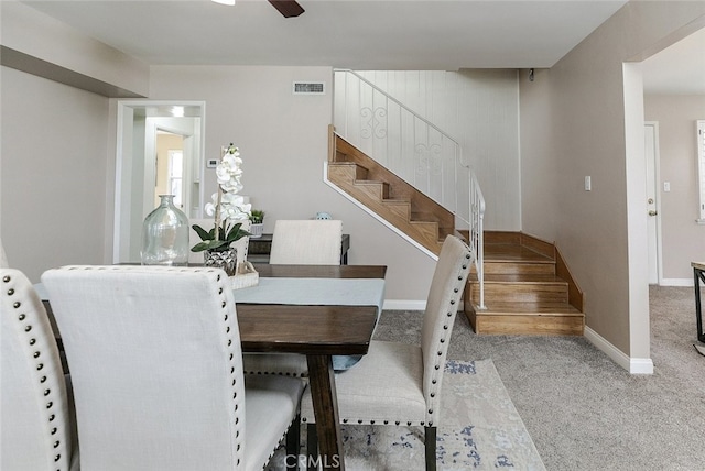 dining space with light colored carpet and ceiling fan