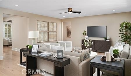 living room featuring ceiling fan and light wood-type flooring