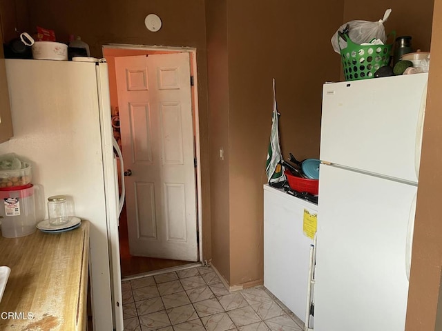 kitchen featuring white fridge and white cabinets