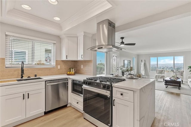 kitchen featuring sink, range with gas cooktop, white cabinetry, island range hood, and stainless steel dishwasher