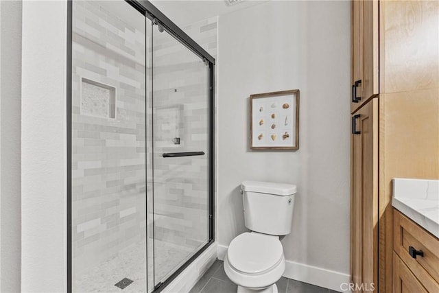 bathroom featuring vanity, an enclosed shower, tile patterned floors, and toilet