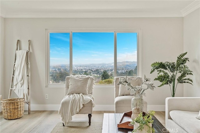 sitting room with hardwood / wood-style flooring, ornamental molding, and a healthy amount of sunlight