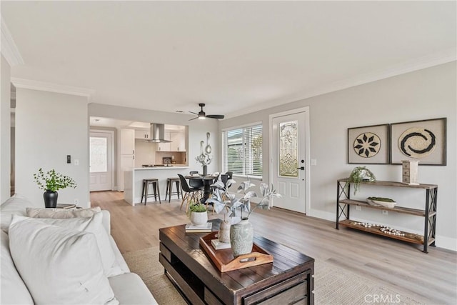 living room featuring crown molding, light hardwood / wood-style floors, and ceiling fan