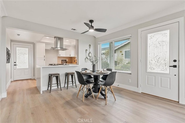 dining room with ornamental molding, light hardwood / wood-style floors, and ceiling fan