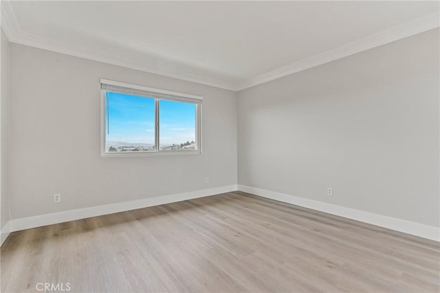 unfurnished room featuring crown molding and light wood-type flooring